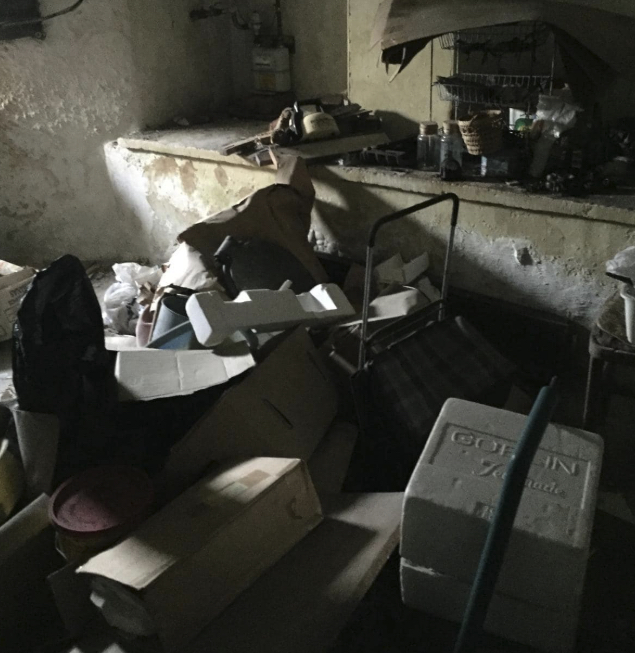 Dark room packed with boxes and old equipment